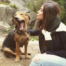 Woman with dog sitting outdoors