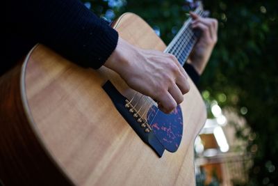 Cropped hands of man playing guitar