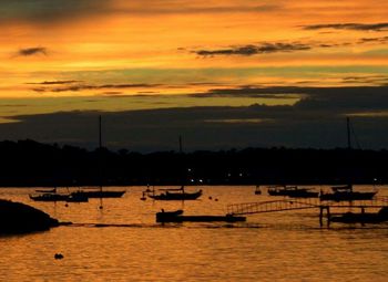 Boats in sea at sunset