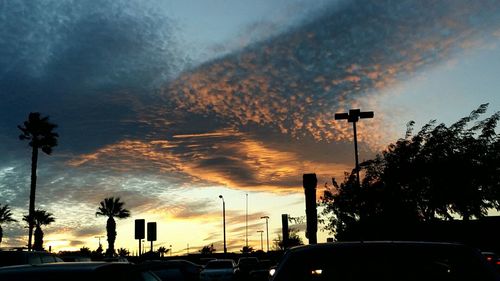 Cars on parking lot against cloudy sky