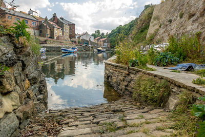 Canal amidst buildings against sky