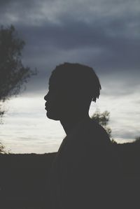 Silhouette of woman against cloudy sky