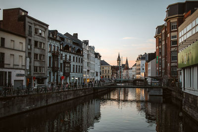 Canal amidst buildings against sky at dusk