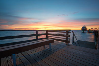 Pier on sea against sky during sunset