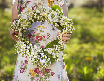 Close-up of woman holding bouquet of flowering plant