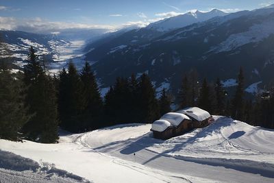 Ski lift by snowcapped mountains against sky