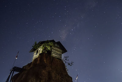 Low angle view of house on mountain against sky at night