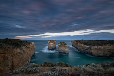 Rocks on sea against sky during sunset