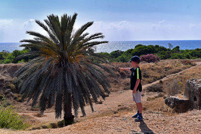 Side view of boy standing on land at beach