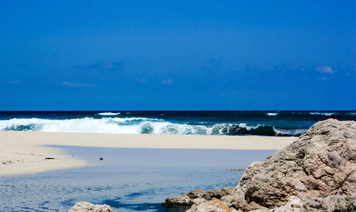 Scenic view of beach against clear blue sky