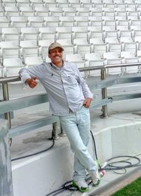 Full length portrait of smiling man standing at stadium