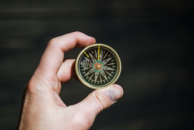 Cropped hand of man holding compass