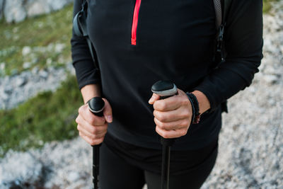 Midsection of man holding camera while standing on land