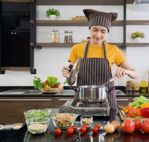 Full length of woman standing in kitchen at home