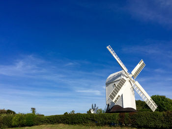 Traditional windmill on field against sky