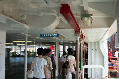 Rear view of people standing on railway station platform