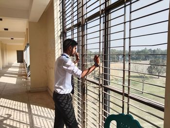 Rear view of man standing by fence