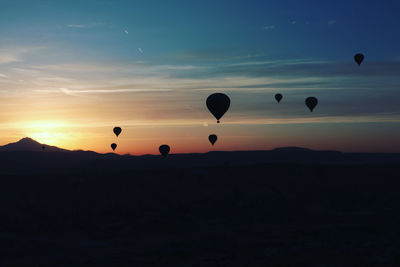 Silhouette hot air balloon against sky during sunset