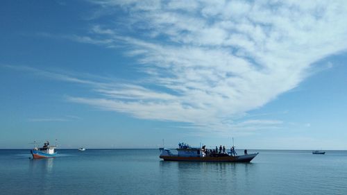 Boats sailing in sea against sky