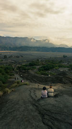 Rear view of man sitting on landscape