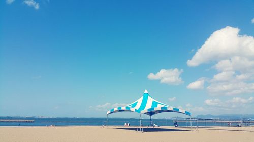Lifeguard hut on beach against blue sky