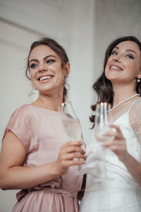 Portrait of a smiling young woman drinking glass