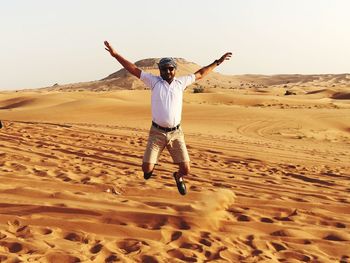 Full length of man jumping in desert