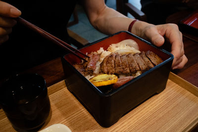 Midsection of person having food on table