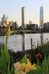 Scenic view of river by buildings against sky