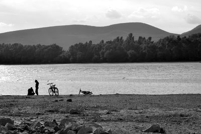 People on shore against sky