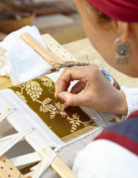 High angle view of woman embroidering fabric