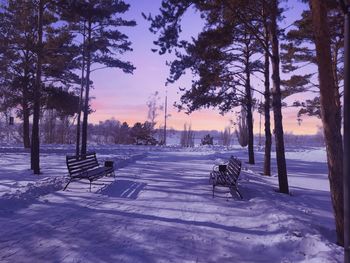 Rear view of man sitting on snow covered landscape,sunrise on the embankment in winter