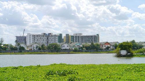 Scenic view of lake by buildings against sky