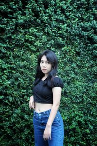 Portrait of woman standing against plants