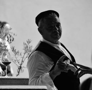 Cropped hand of person and man pointing against drink in glass on table