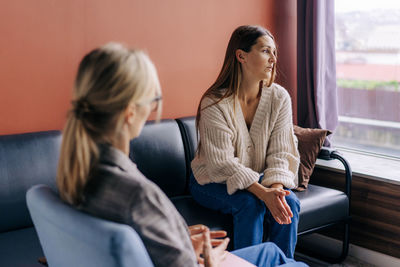 Sad frustrated woman talking in a session with a psychotherapist about her problems.