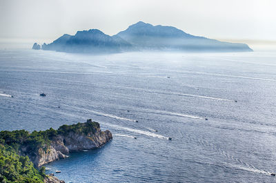 Scenic view of sea and mountains against sky