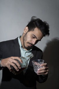 Mid section of a man drinking glass