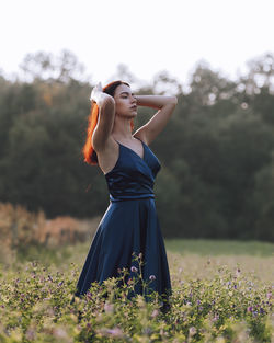 Youmg woman in blue dress standing in the field