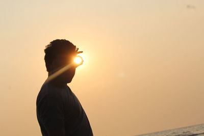 Silhouette man standing against sky during sunset