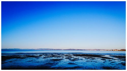 Scenic view of sea against clear blue sky