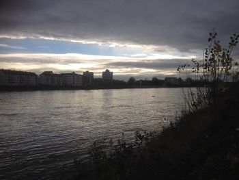 River against cloudy sky at sunset