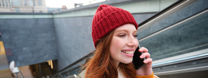 Portrait of young woman looking away while standing outdoors