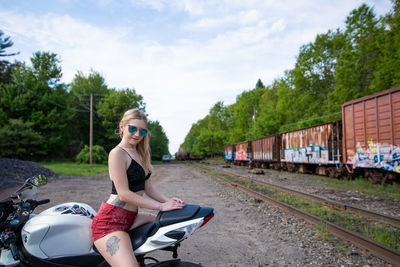 Woman standing on railroad track against sky