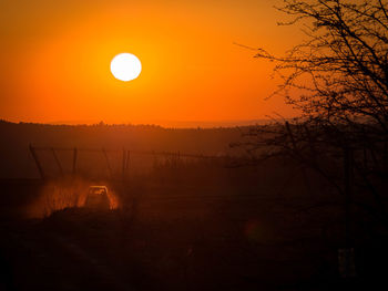 Scenic view of silhouette landscape against orange sky