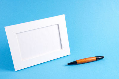 High angle view of cigarette on table against blue background