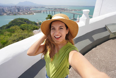 Woman takes self portrait with panoramic view of vitoria city in the state of espirito santo, brazil