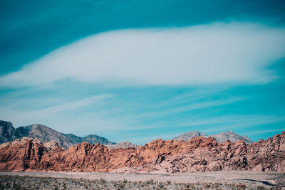 Scenic view of mountains against blue sky