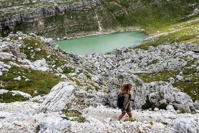 Woman walking on mountain by lake