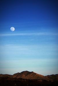 Scenic view of mountains against blue sky